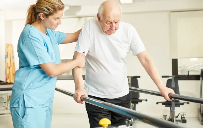 Woman helping man with physical therapy